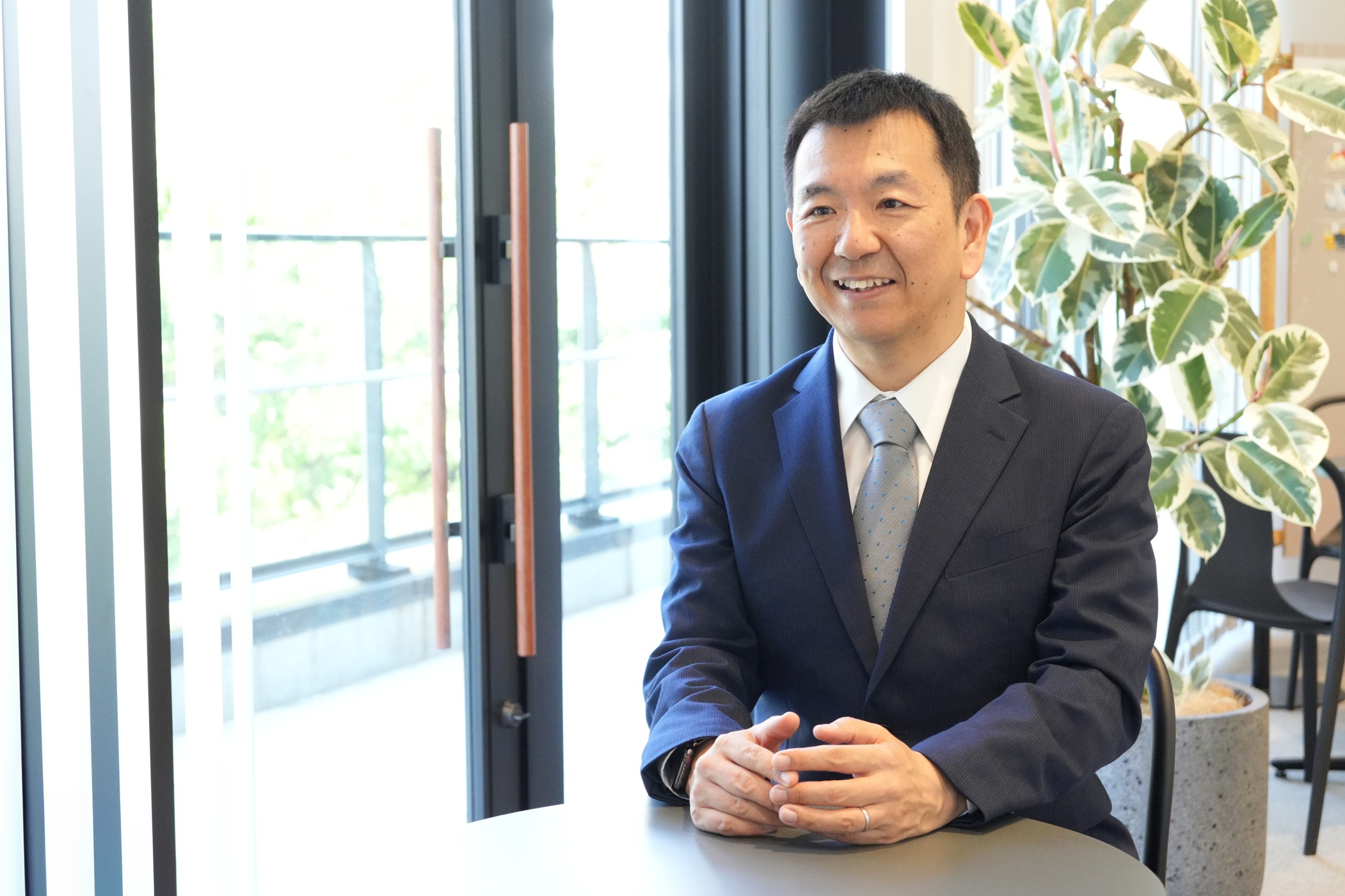 写真:微笑みながら話を聞くスーツ姿の男性