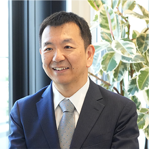 写真:微笑みながら話を聞くスーツ姿の男性